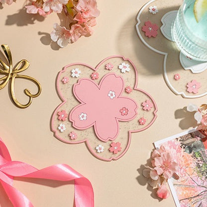 un dessous de verre en forme de fleur de sakura rose tout pailleté. Pratique, résistant, il décore avec élégance votre table