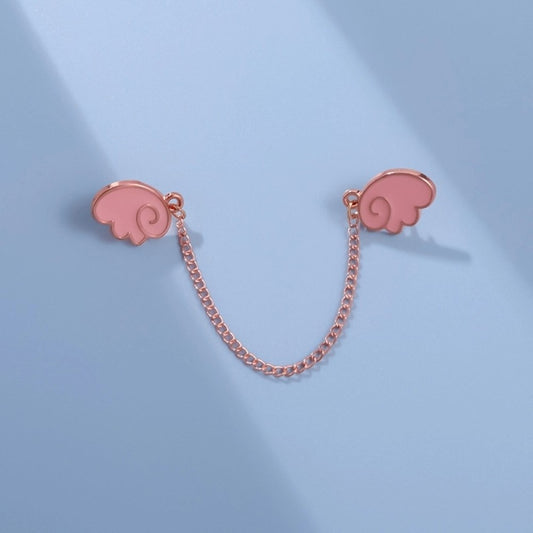 un double pin's en forme d'ailes rose façon chibi et kawaii reliés chacun à l'autre par une chainette rose gold.