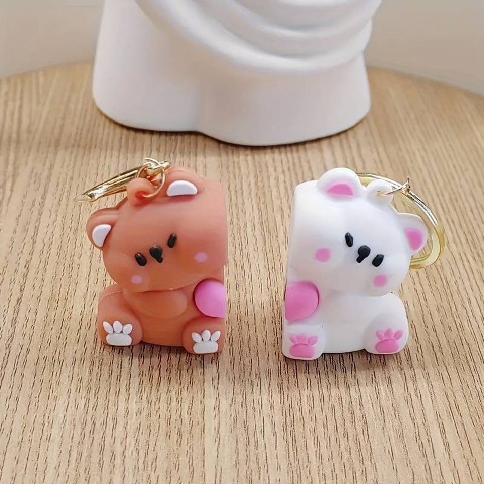 un double porte-clés composé de deux adorables oursons, un brun et un blanc, collés l'un à l'autre par un aimant; Ils partagent un coeur rose. On peut les séparer puis les réunir.