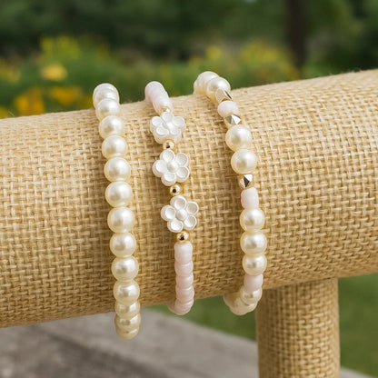 un ensemble de 3 bracelets perles blanches et rosés. Un bracelet comporte des fleurs de sakura. L'ensemble est poétique, romantique et bohème.