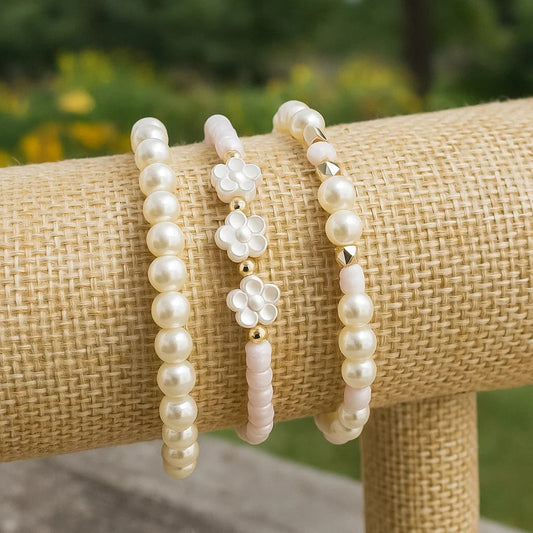 un ensemble de 3 bracelets perles blanches et rosés. Un bracelet comporte des fleurs de sakura. L'ensemble est poétique, romantique et bohème.