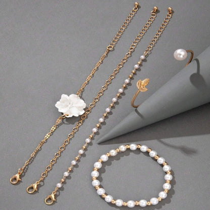 un ensemble de bracelets dorés avec des perles blanches et une fleur blanche. Style bohème, chic et élégant. 