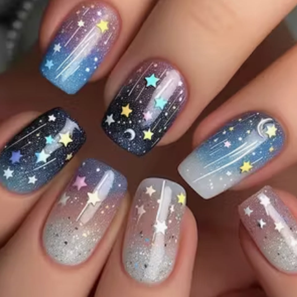 des faux ongles press on nails au motif et couleurs d'une galaxie étoilée. Dans les couleurs bleu, violet, rose et blanc, ce nail art vous transporte vers les étoiles. Faciles à et pratiques à utiliser grâce aux autocollants !
