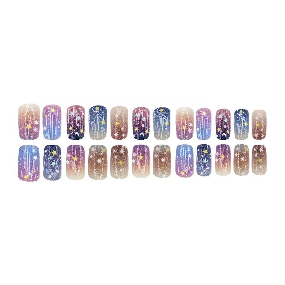 des faux ongles press on nails au motif et couleurs d'une galaxie étoilée. Dans les couleurs bleu, violet, rose et blanc, ce nail art vous transporte vers les étoiles. Faciles à et pratiques à utiliser grâce aux autocollants !