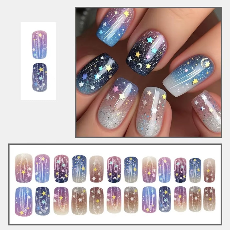 des faux ongles press on nails au motif et couleurs d'une galaxie étoilée. Dans les couleurs bleu, violet, rose et blanc, ce nail art vous transporte vers les étoiles. Faciles à et pratiques à utiliser grâce aux autocollants !