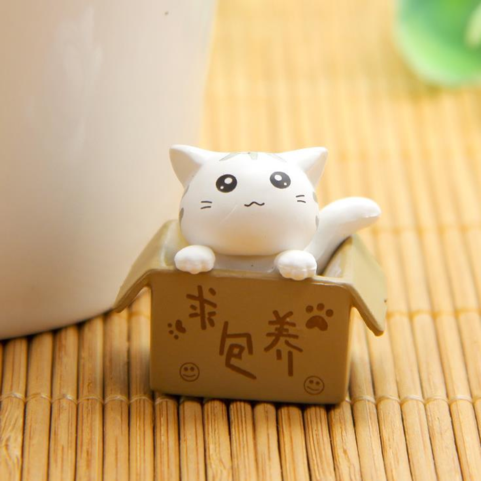 des figurines de chat bien lovés dans leur boite en carton : gris, noir, blanc ou roux, ils sont adorables. Parfait pour décorer une pièce avec style et mignonnerie