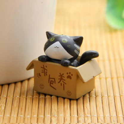 Figurine chat dans son carton