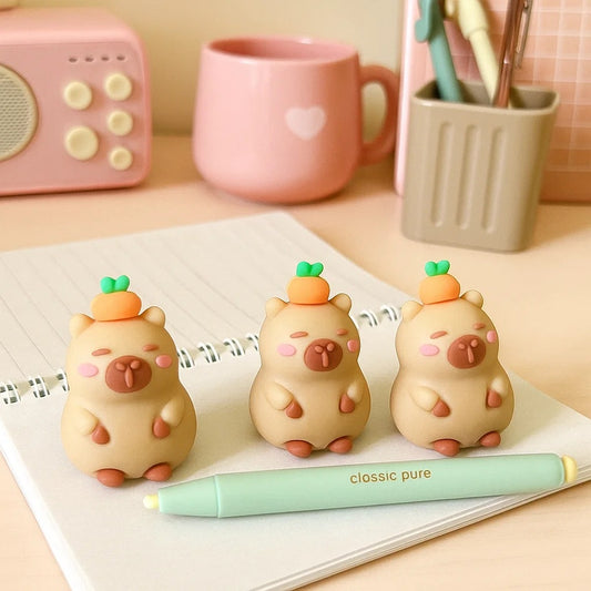 une adorable gomme en forme de capybara. Une petite orange est posée sur sa tête. L'ensemble est amusant et mignon.