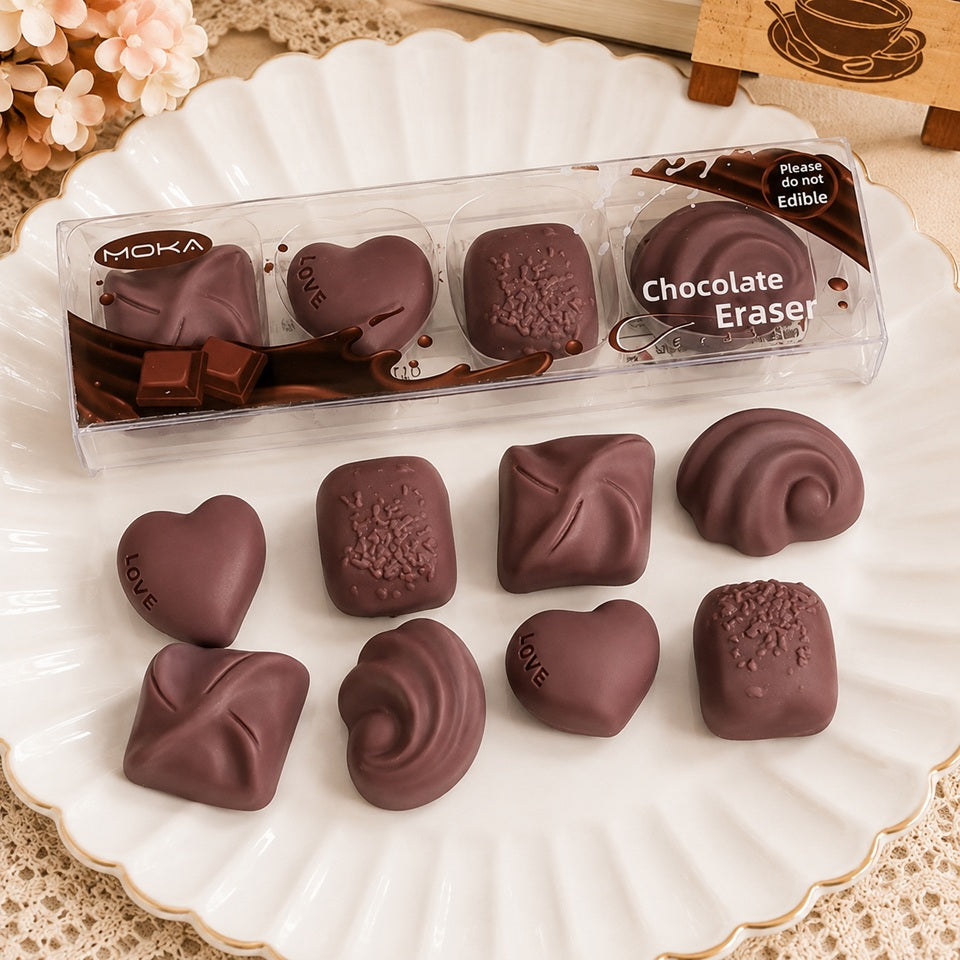 Lot de 4 gommes en forme de chocolats, présentées dans une boîte transparente façon assortiment de pralines, papeterie kawaii originale et gourmande.