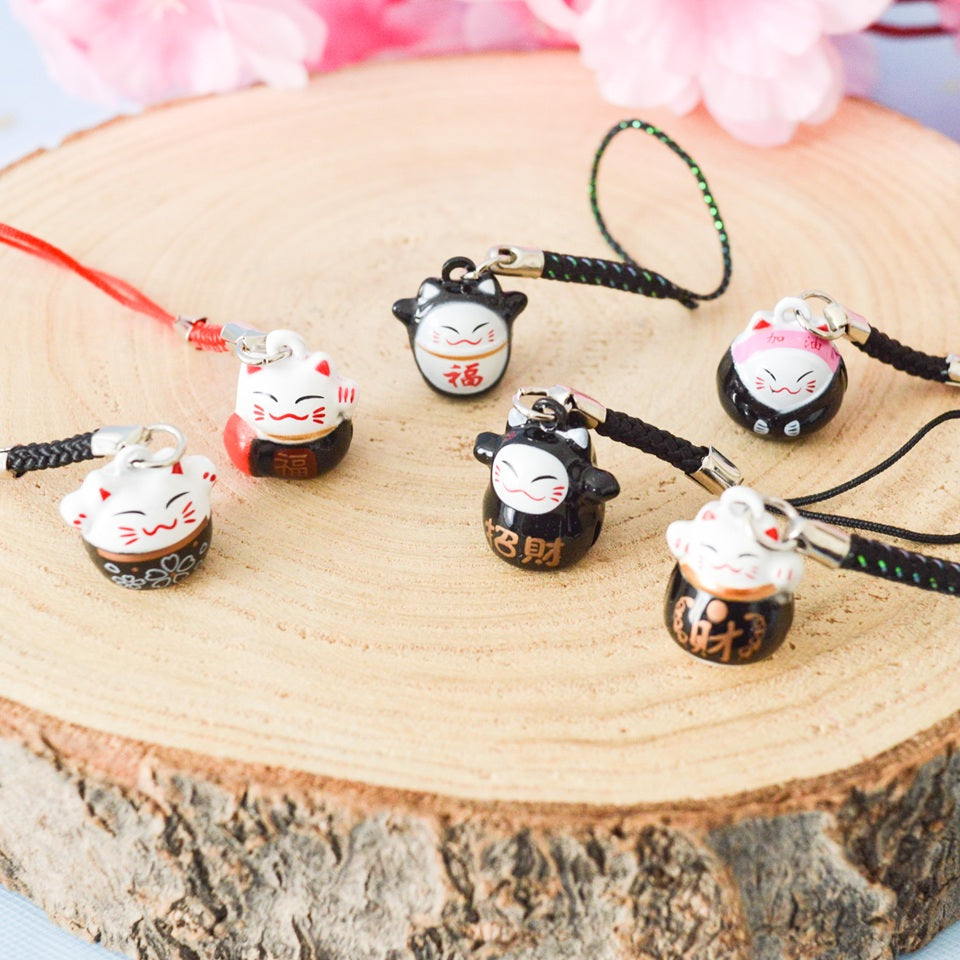 des porte-clés en forme de maneki neko sous forme de grelot. Il y a plusieurs couleurs et designs différents. 