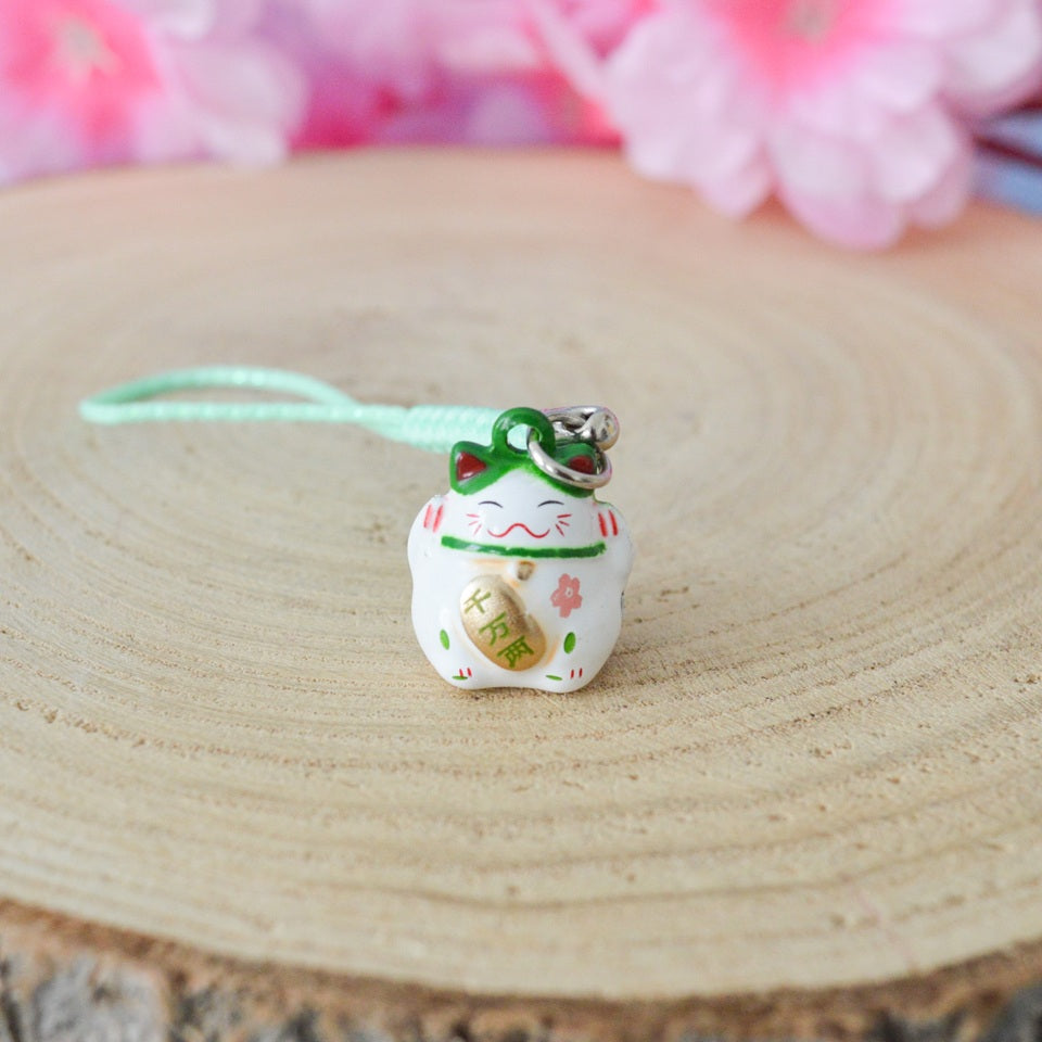 des porte-clés en forme de maneki neko sous forme de grelot. Il y a plusieurs couleurs et designs différents. 