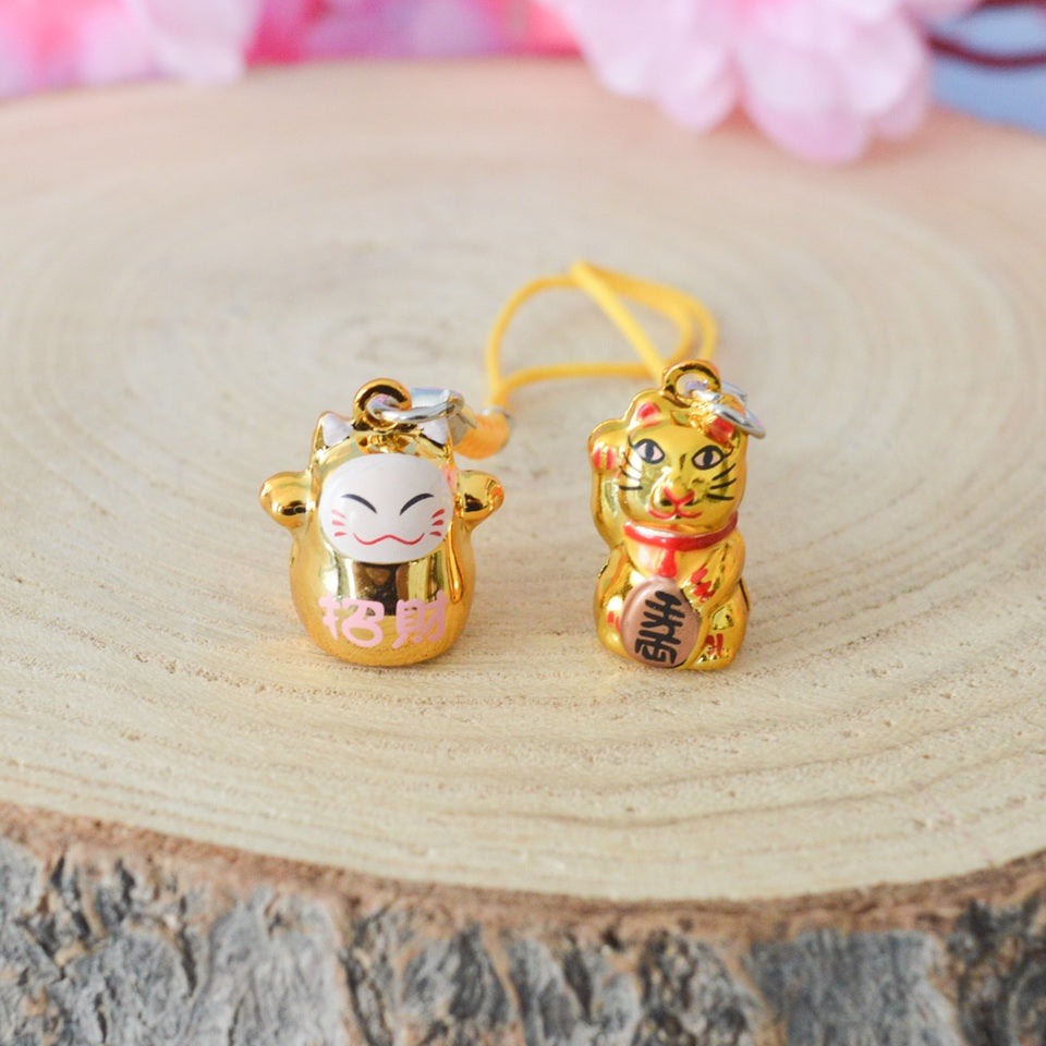 des porte-clés en forme de maneki neko sous forme de grelot. Il y a plusieurs couleurs et designs différents. 