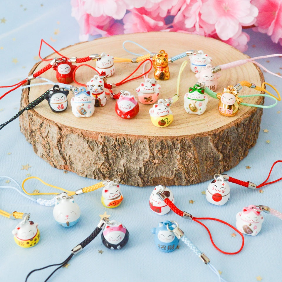 des porte-clés en forme de maneki neko sous forme de grelot. Il y a plusieurs couleurs et designs différents. 