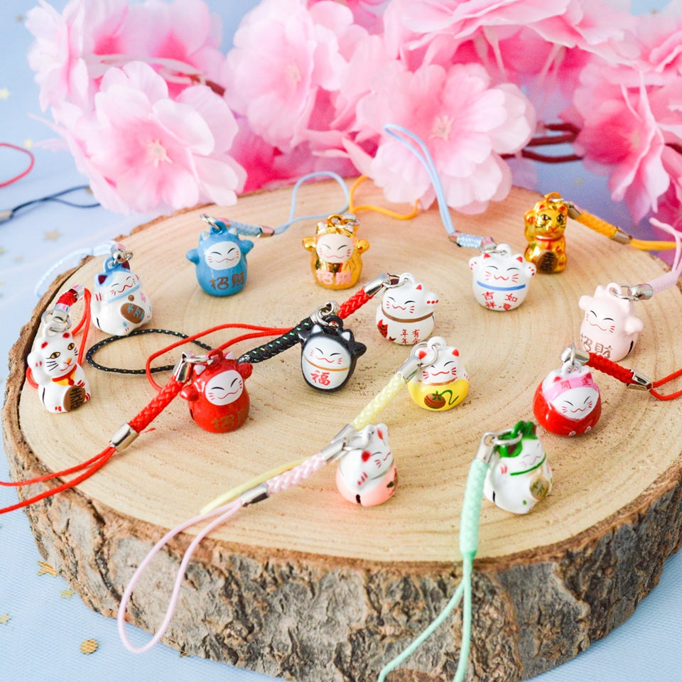 des porte-clés en forme de maneki neko sous forme de grelot. Il y a plusieurs couleurs et designs différents. 