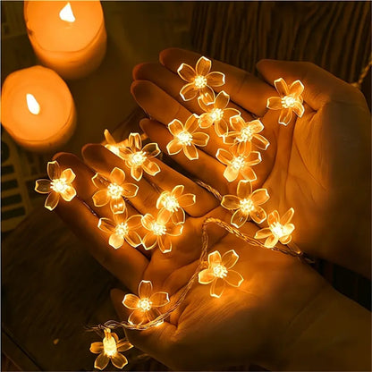 une guirlande LED en forme de fleurs de sakura toutes mignonnes. Elle diffuse une lumière jaune chaude et chaleureuse. Idéale pour créer une ambiance cocooning