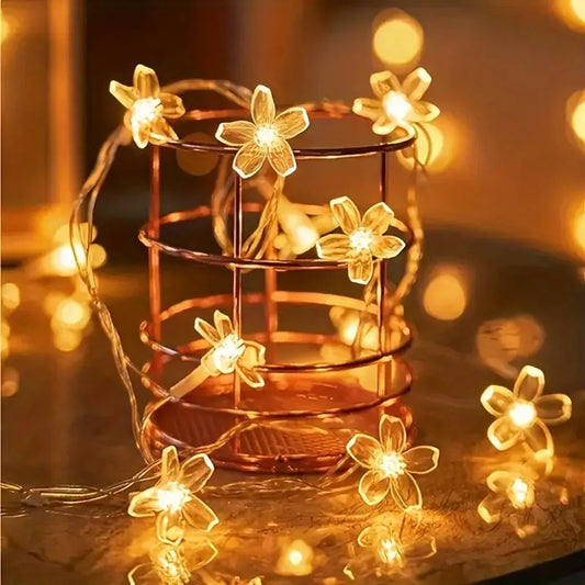 une guirlande LED en forme de fleurs de sakura toutes mignonnes. Elle diffuse une lumière jaune chaude et chaleureuse. Idéale pour créer une ambiance cocooning
