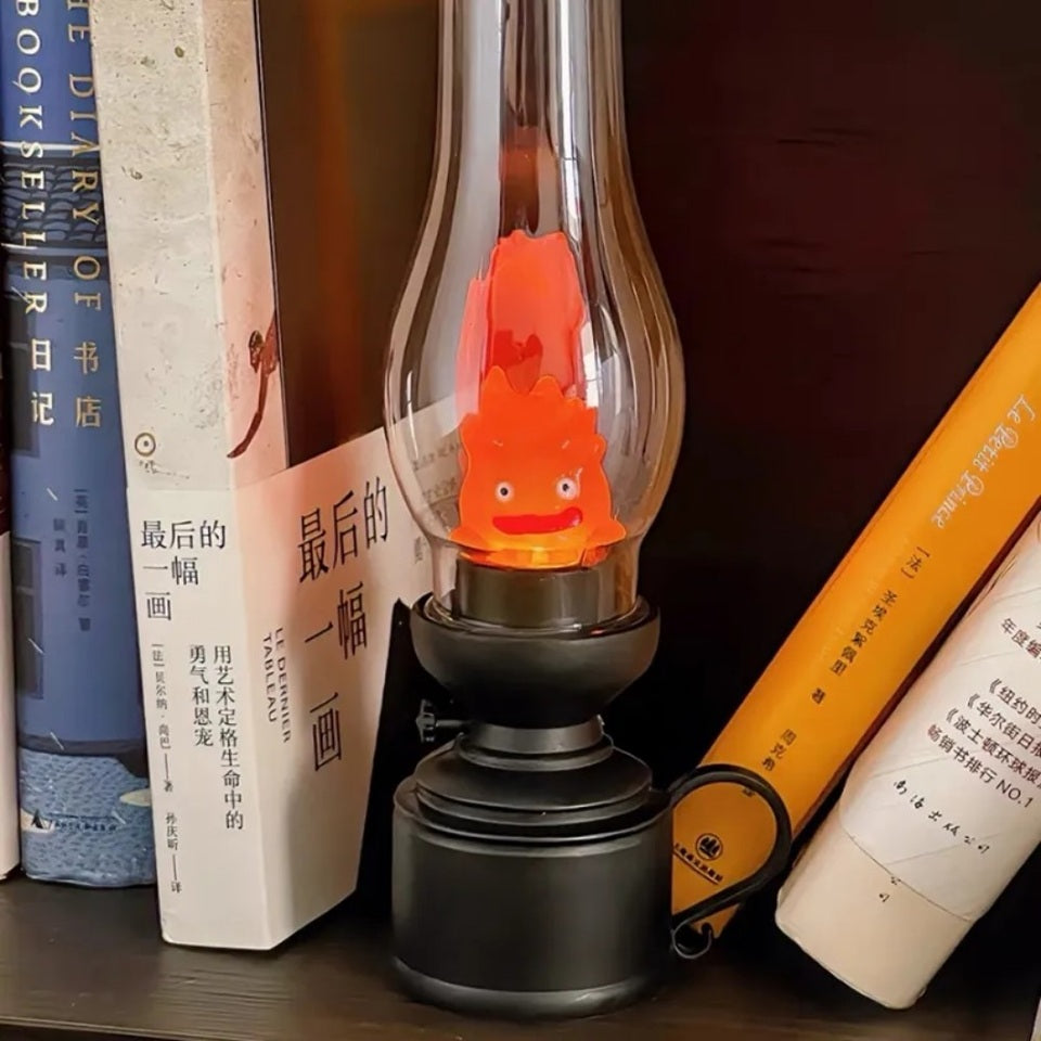 une veilleuse façon vieille lampe à huile dans laquelle se trouve Calcifer, le petit être démoniaque du château ambulant. Enfermé à l'intérieur de cette lampe, il s'allume et éclaire doucement la pièce créant une ambiance apaisante et chaleureuse.