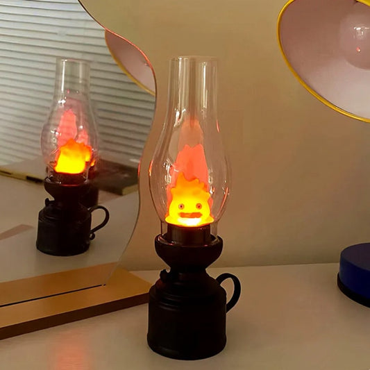 une veilleuse façon vieille lampe à huile dans laquelle se trouve Calcifer, le petit être démoniaque du château ambulant. Enfermé à l'intérieur de cette lampe, il s'allume et éclaire doucement la pièce créant une ambiance apaisante et chaleureuse.