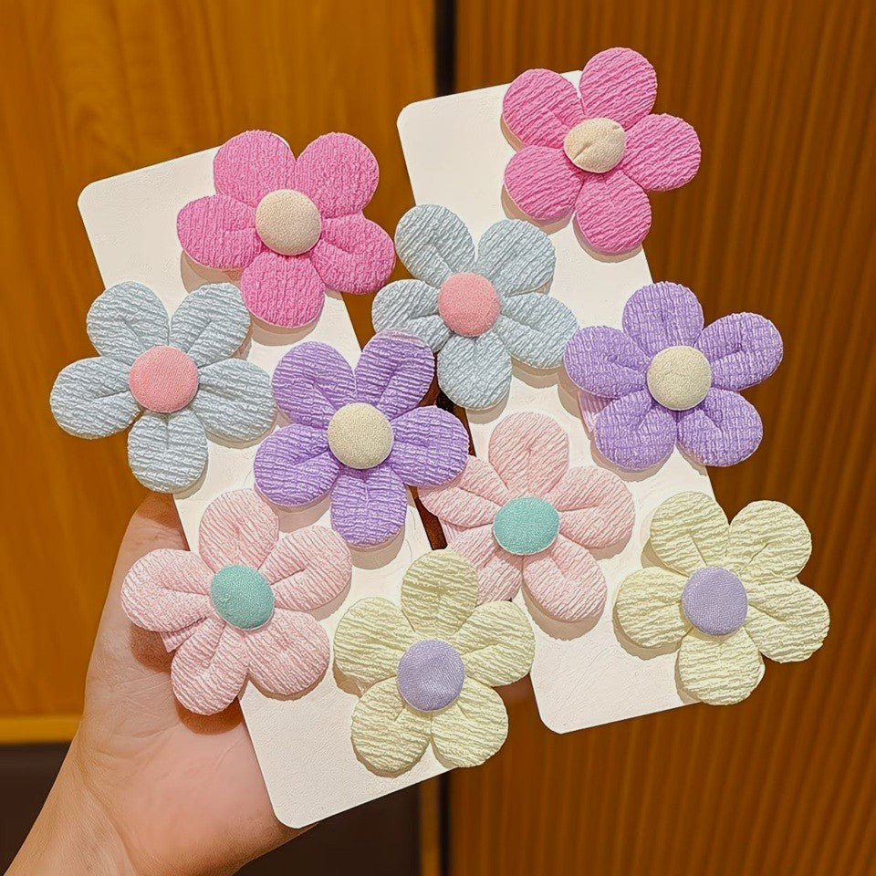 de jolies barrettes à cheveux en forme de petites fleurs rondes colorées en tissu.