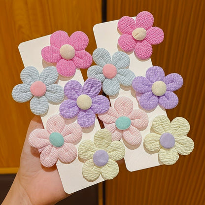 de jolies barrettes à cheveux en forme de petites fleurs rondes colorées en tissu.