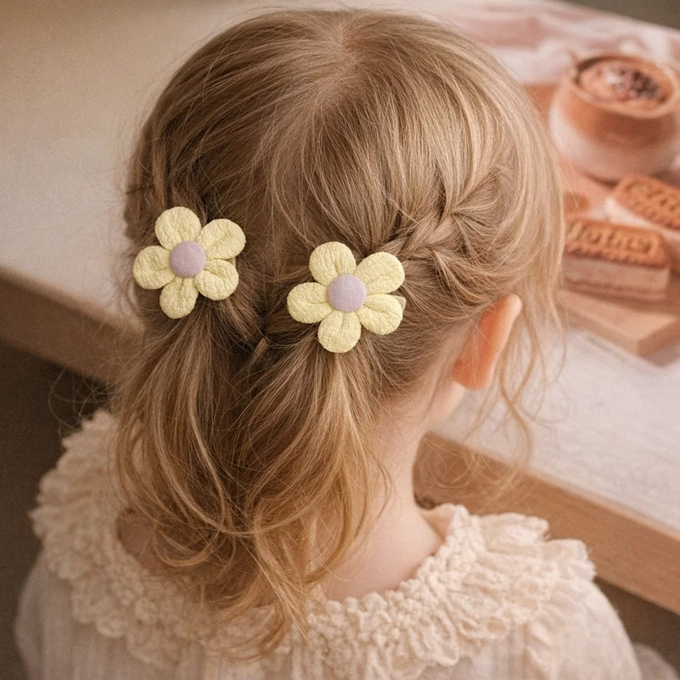 de jolies barrettes à cheveux en forme de petites fleurs rondes colorées en tissu.