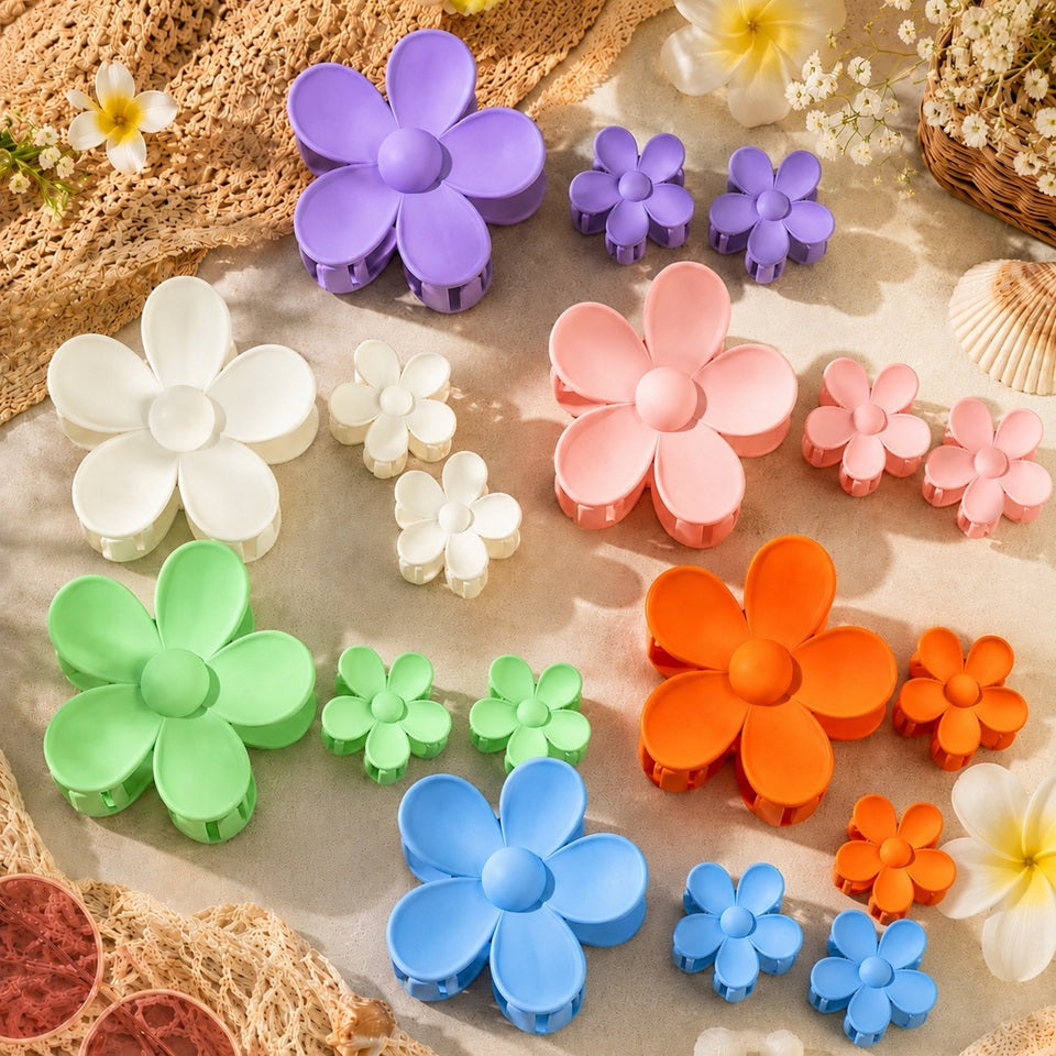 Lot de pinces à cheveux en forme de fleur colorée avec grandes et petites barrettes pastel violette, blanche, rose, verte, orange et bleue, présenté dans un décor estival bohème avec fleurs, coquillages et matières naturelles.