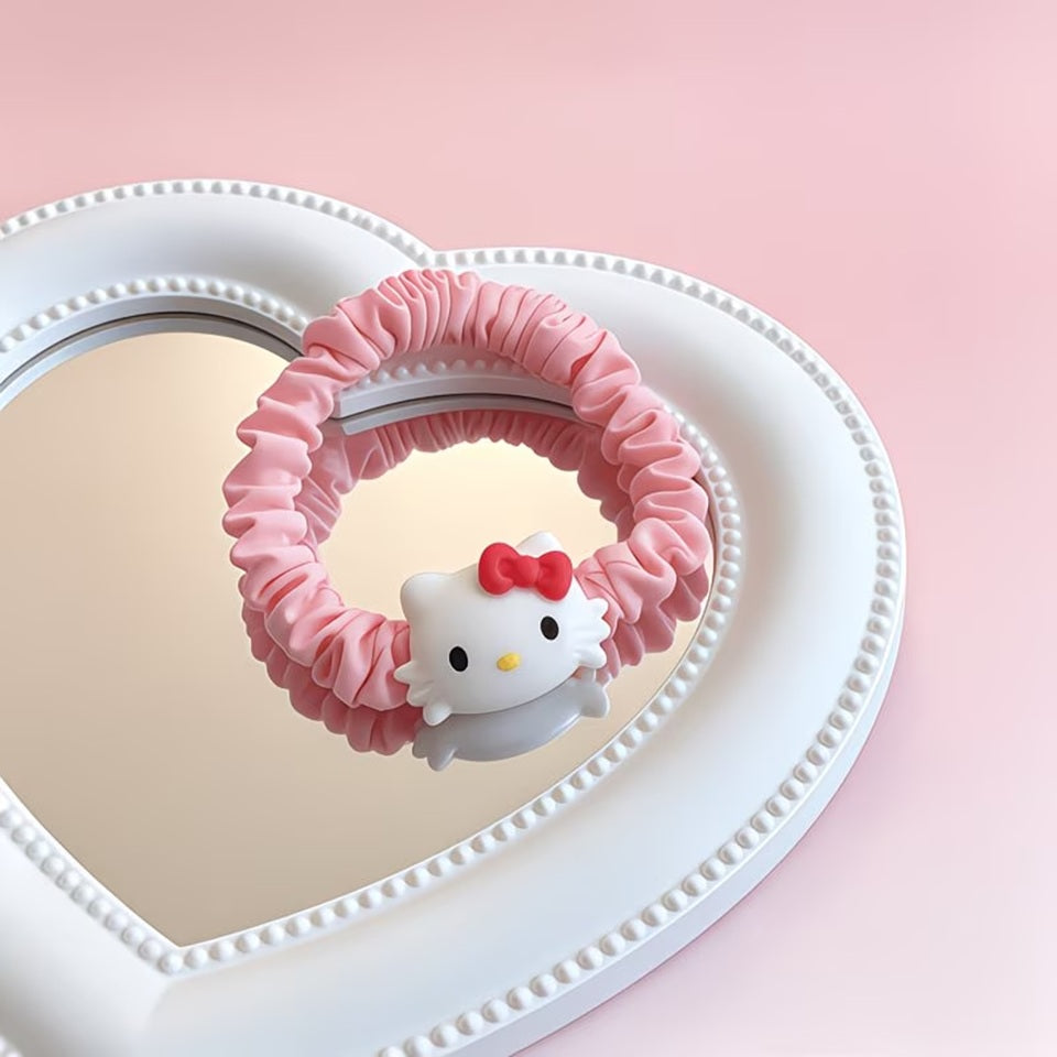 Un joli élastique à cheveux kawaii inspirés de l'univers Sanrio, avec le personnage Hello Kitty. Le chouchou est confectionné dans un tissu satiné aux couleurs pastel rose. Présentés sur une surface élégante, ils ont idéals pour ajouter une note kawaii à votre style.