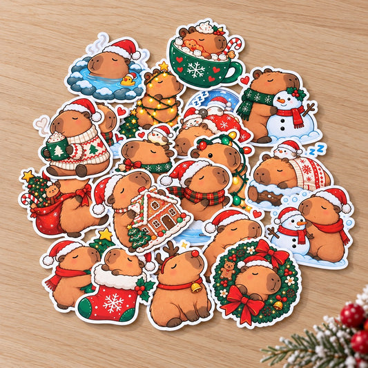 Lot de stickers capybara de Noël kawaii avec bonnets, sapins, cadeaux, bonhommes de neige et décorations festives, disposés sur un bureau en bois clair. Idéal scrapbooking et pour décorer des cadeaux, cartes etc...