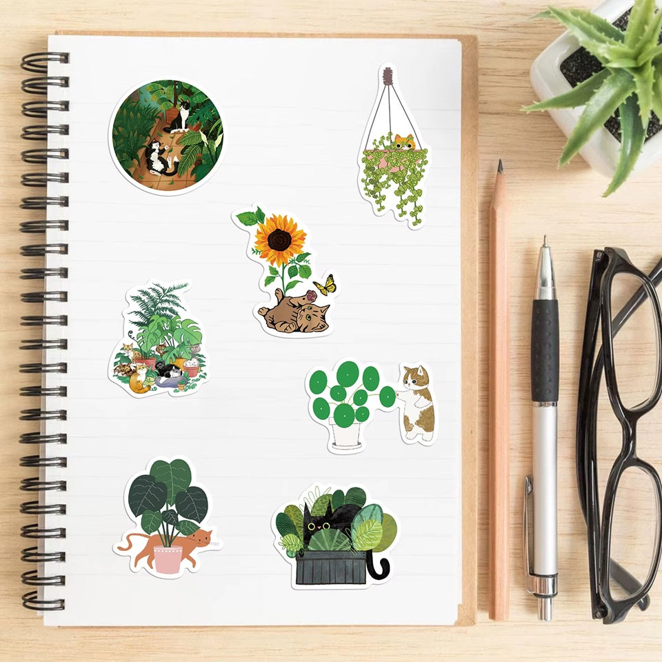 des stickers représentant des chats qui s'amusent et jouent dans des plantes vertes. Malice, mignonnerie et jolis décors de plantes idéals pour le scrapbooking.