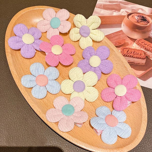 de jolies barrettes à cheveux en forme de petites fleurs rondes colorées en tissu.