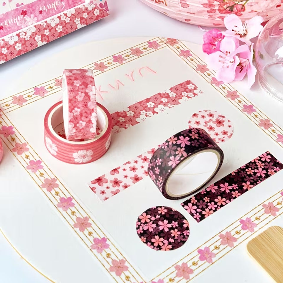 Gros plan sur des washi tape au motif de fleurs de sakura rose clair et rose foncé.  Idéal pour une touche florale et romantique qui rappelle les cerisiers en fleurs du Japon.