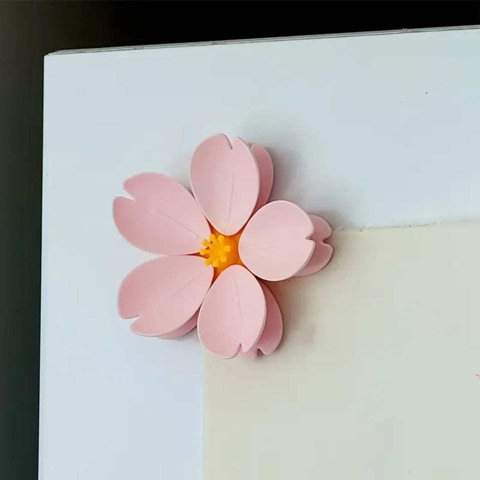 un magnet en forme de fleur de sakura : son coeur est mangnétique et cinq pétales détachables l'entoure. Ce sont des pinces que l'on utiliser pour fermer des paquets de nourriture mais aussi pour tenir des papiers.