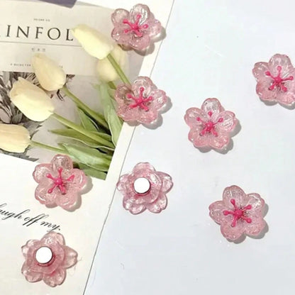 des magnets tout mignons roses et pailletés en forme de fleur de sakura. Idéal pour le bureau !