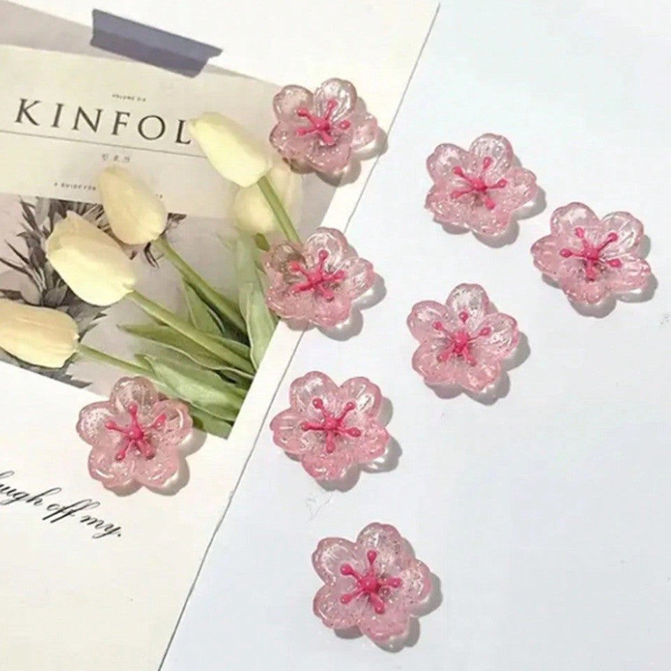 des magnets tout mignons roses et pailletés en forme de fleur de sakura. Idéal pour le bureau !