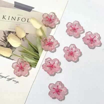 des magnets tout mignons roses et pailletés en forme de fleur de sakura. Idéal pour le bureau !