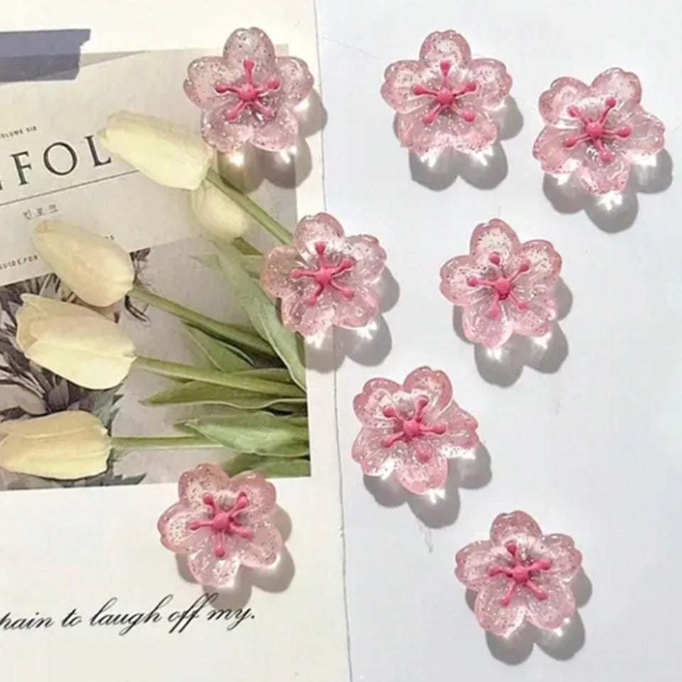 des magnets tout mignons roses et pailletés en forme de fleur de sakura. Idéal pour le bureau !