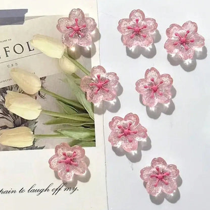des magnets tout mignons roses et pailletés en forme de fleur de sakura. Idéal pour le bureau !