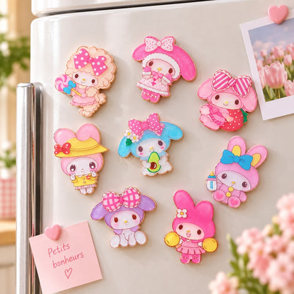 Magnets My Melody et My Sweet Piano roses et colorés, décorés de détails pailletés et disposés sur un réfrigérateur avec une photo et un petit mot.
