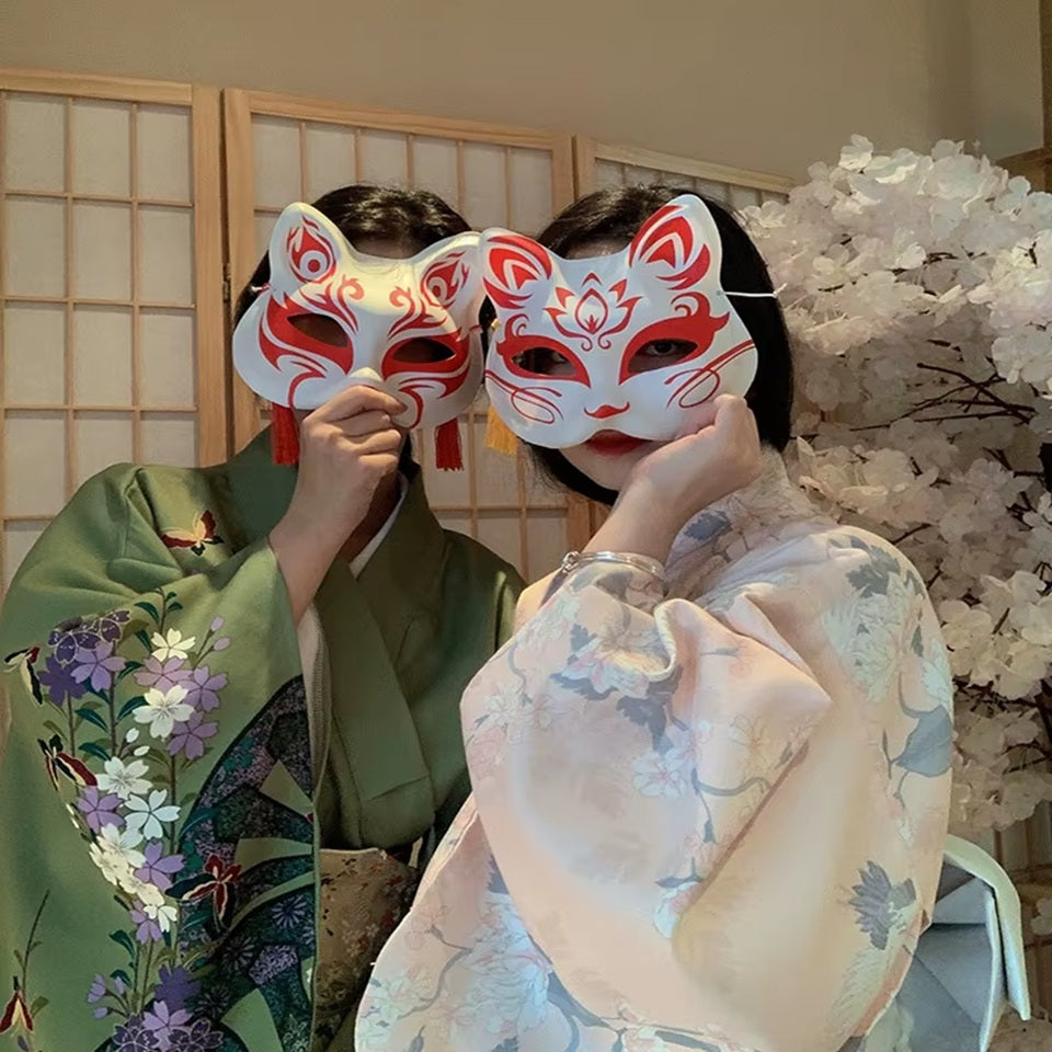 un masque kitsune rouge stylisé, avec des pompons et clochettes.  En palstique souple, il est parfait pour le cosplay et les soirées déguisées. Il est très beau même en décoration