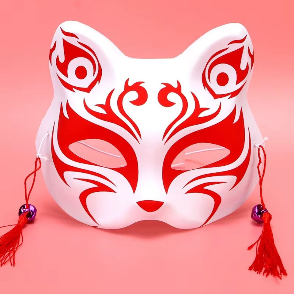 un masque kitsune rouge stylisé, avec des pompons et clochettes.  En palstique souple, il est parfait pour le cosplay et les soirées déguisées. Il est très beau même en décoration