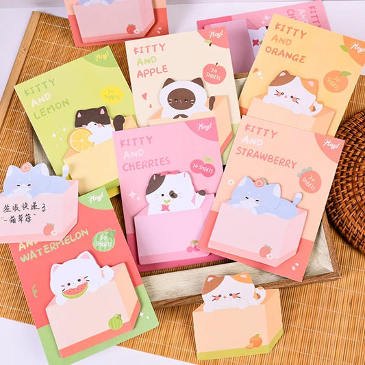 des mémos adhésifs trop mignons en forme de chats roux, blanc, gris ou noirs bien posé dans leur carton. Design adorable et amusant.