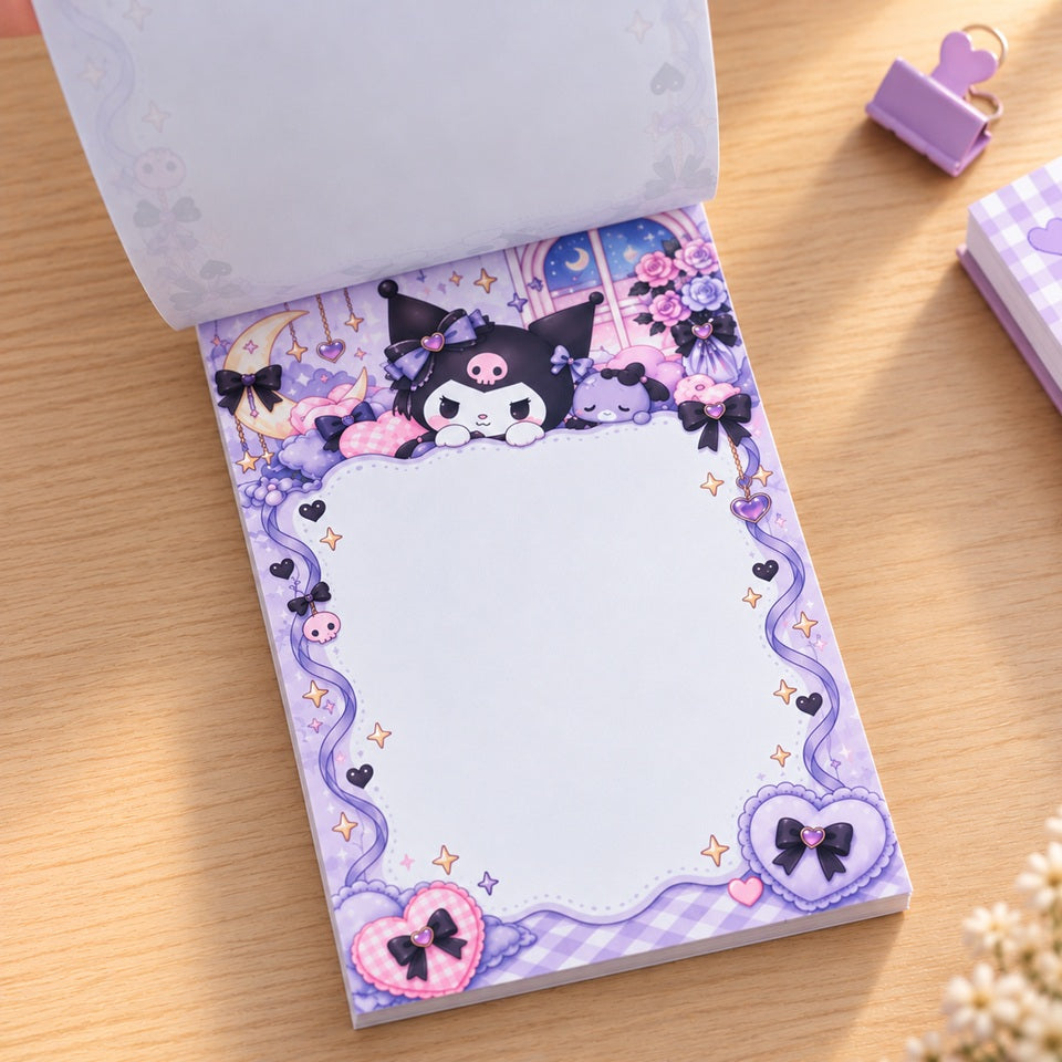 Bloc mémo rectangulaire Kuromi kawaii aux tons violet et rose pastel, décoré de cœurs, nœuds et étoiles, avec une grande zone blanche pour écrire et une feuille soulevée, présenté sur un bureau en bois clair.