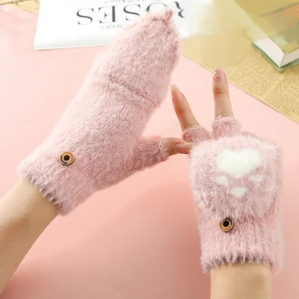 une paire de mitaines roses au design d'une patte de chat en forme de coeur qui se transforme en moufle en un clin d'oeil