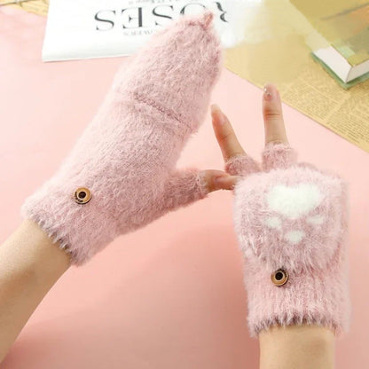 une paire de mitaines roses au design d'une patte de chat en forme de coeur qui se transforme en moufle en un clin d'oeil