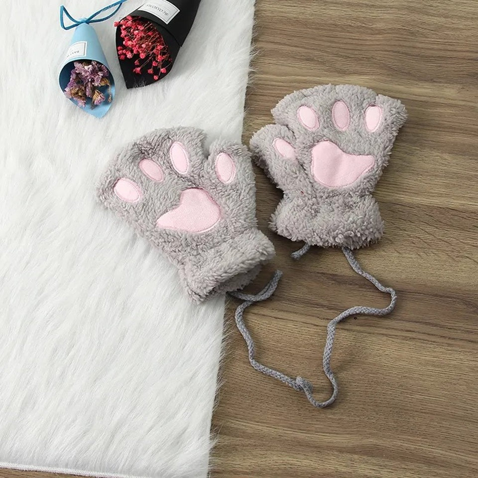 une paire de mitaines tout en peluche  grises et roses en forme de patte de chat. 