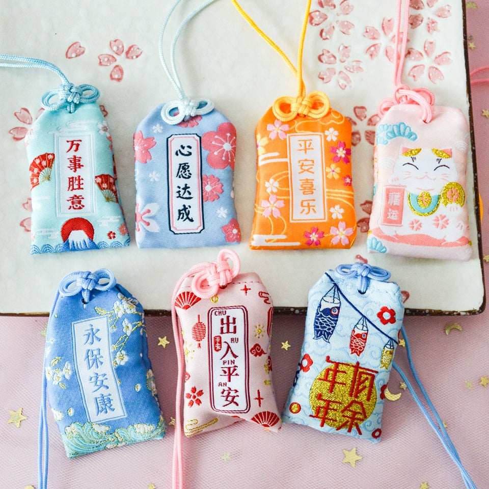 des omamori, porte-bonheur japonais aux motifs et couleurs variés selon le type desouhait : amour, bonheur, argent, paix et sécurité etc... A remplir puis offrir.