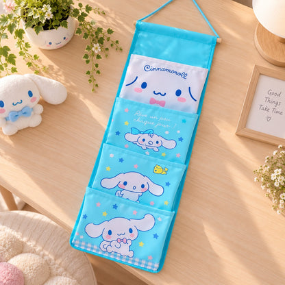 Rangement mural Cinnamoroll bleu à plusieurs poches, présenté à plat sur une table en bois dans un décor kawaii lumineux et épuré.