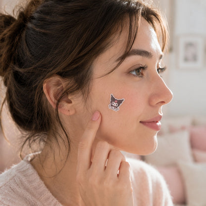 une jeune femme dans un univers beauté aux tons rose poudré porte un patch anti-boutons en forme de Kuromi sur la joue. L'ambiance est douce et lumineuse. Le patch est mis en valeur comme accessoires de soin à la fois pratique et esthétique.