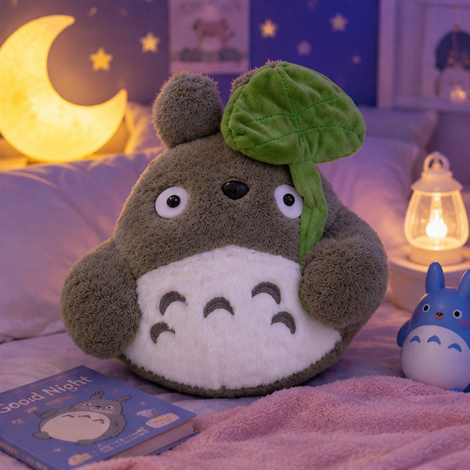 Peluche Totoro kawaii ultra douce tenant une grande feuille verte dans une ambiance nocturne cosy et féerique ✨ Peluche moelleuse inspirée d’un univers japonais magique avec lune lumineuse, lanternes et décoration pastel réconfortante. Parfaite pour décorer une chambre, offrir un cadeau adorable ou créer une ambiance cocooning kawaii.
