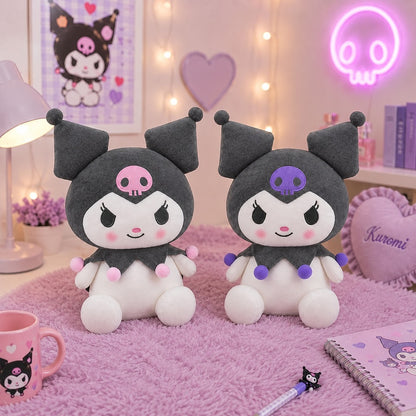 Deux peluches Kuromi kawaii noires et blanches avec tête de mort rose et violette et pompons colorés, présentées dans une jolie chambre pastel rose et lilas.